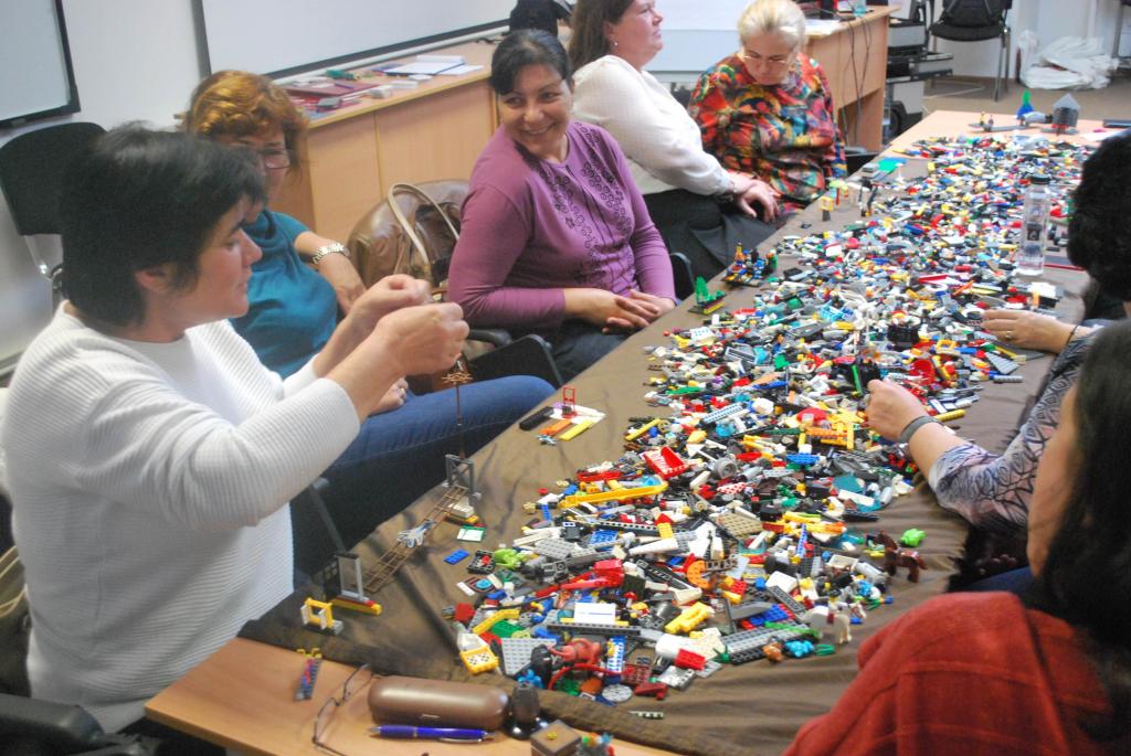 Profesori într-un atelier SuperDascăl, lucrând împreună la o activitate.